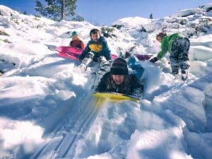 kids sledding down snowy hill