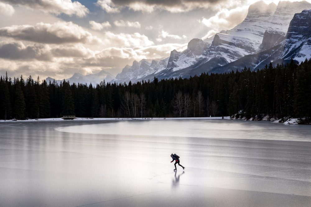 solo man ice skating in Banff National Park