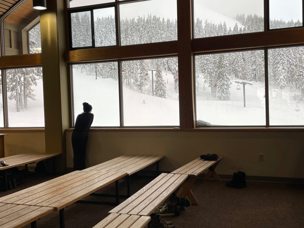 man looking out snowy window - family things to do in Bend Oregon