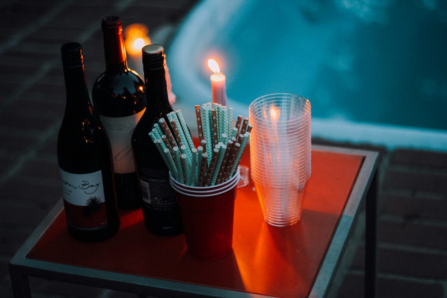 Wine bottles and candle near hot tub. Romantic cabin getaways with hot tubs in Virginia. 