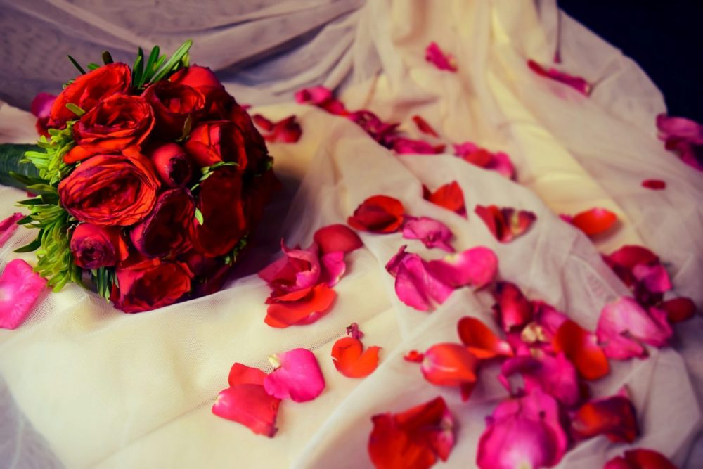 Rose petals on white fabric. Romantic getaways in Ohio with hot tubs.