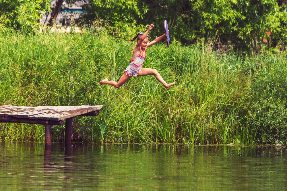 kid jumping off dock, eco hotels for families, family travel, earth day
