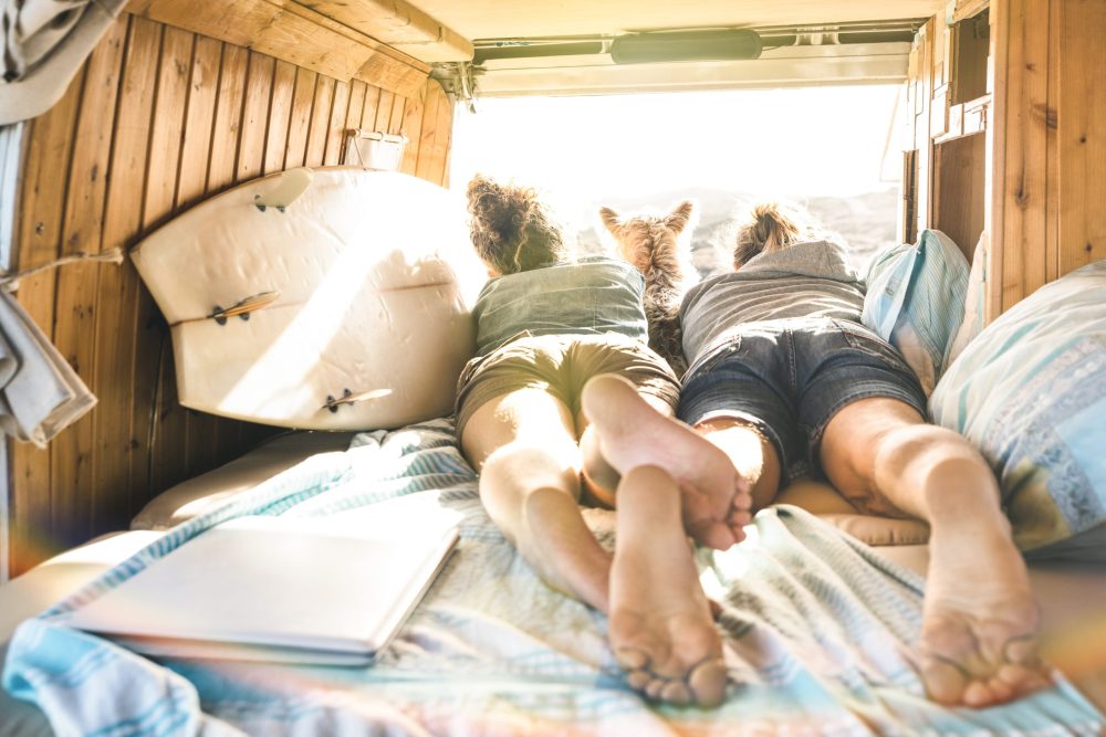 Interior of a campervan with couple peaking out the back window-Campervan life in LA