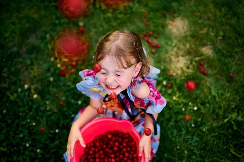 cherries falling on a laughing girl