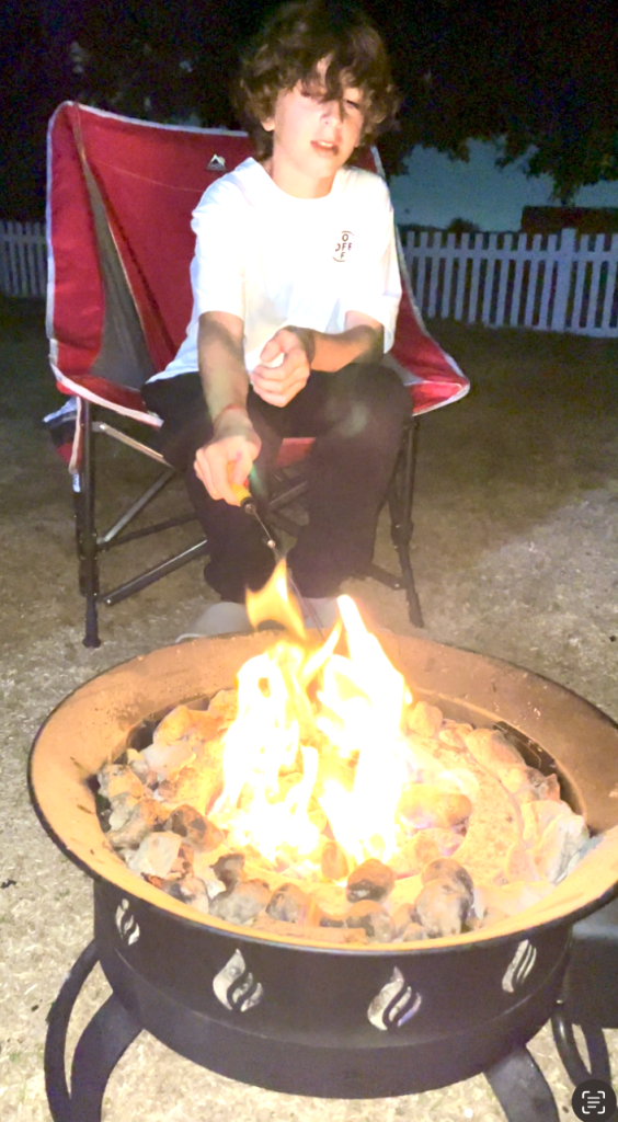 boy at campfire in newport dunes