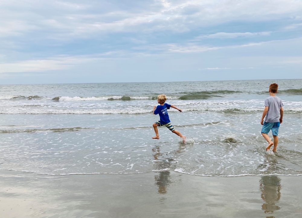 two boys running through the waves