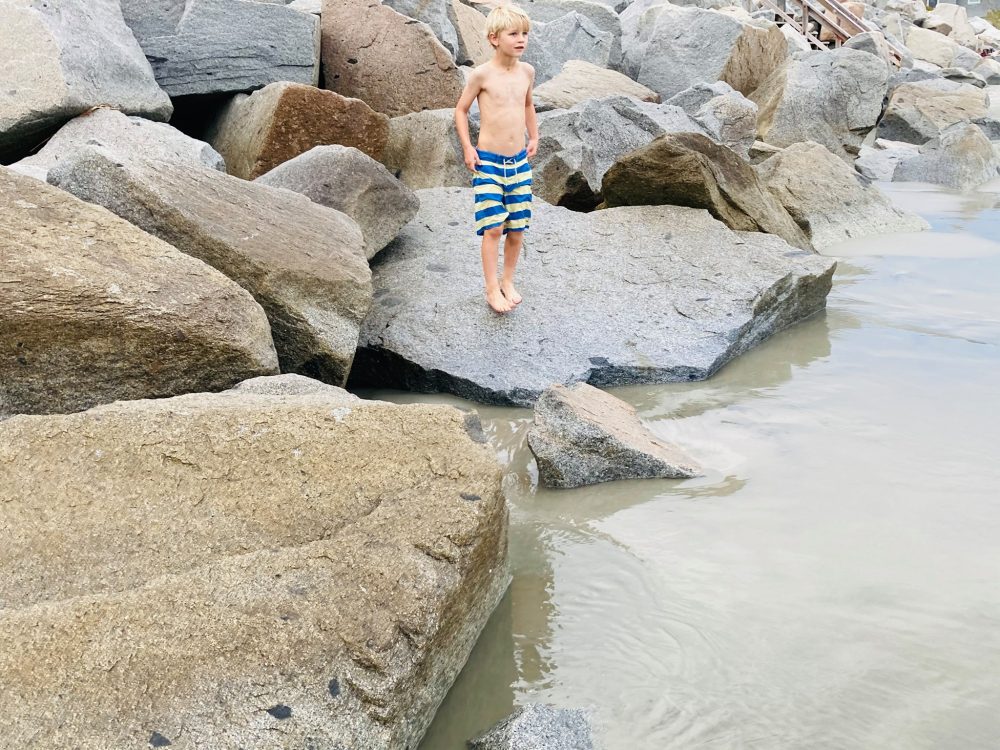 little boy on rocky shore of the Atlantic 
