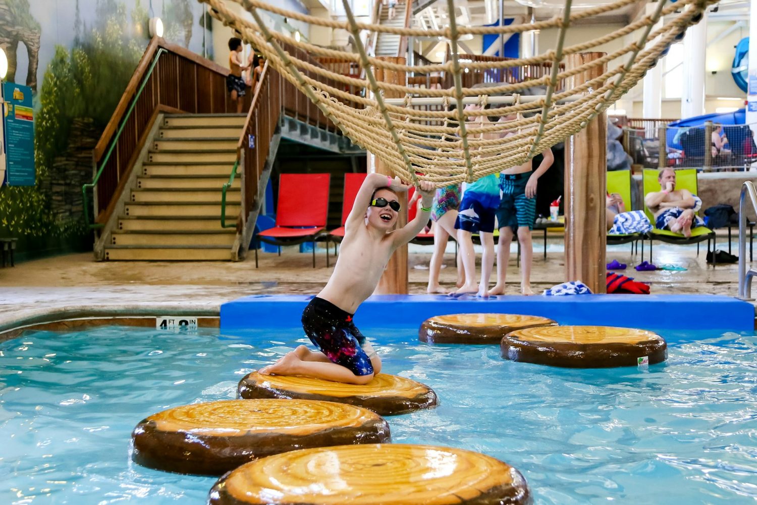 Kid playing on water playground. Hotels with indoor waterparks.