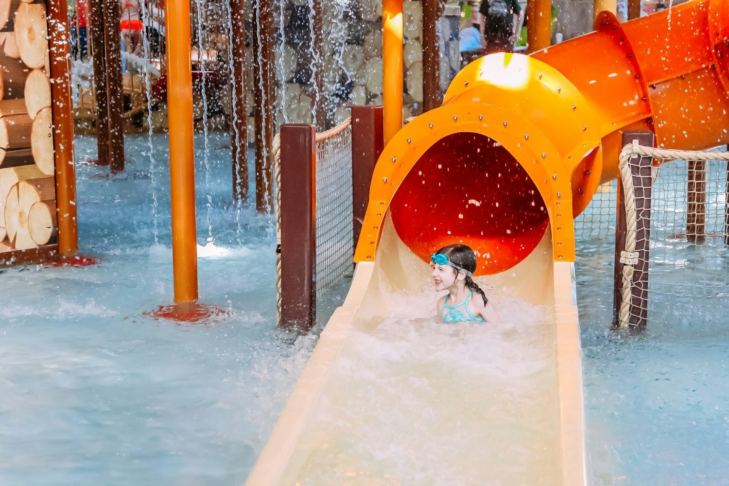 Girl coming down waterslide. Hotels with indoor waterparks.