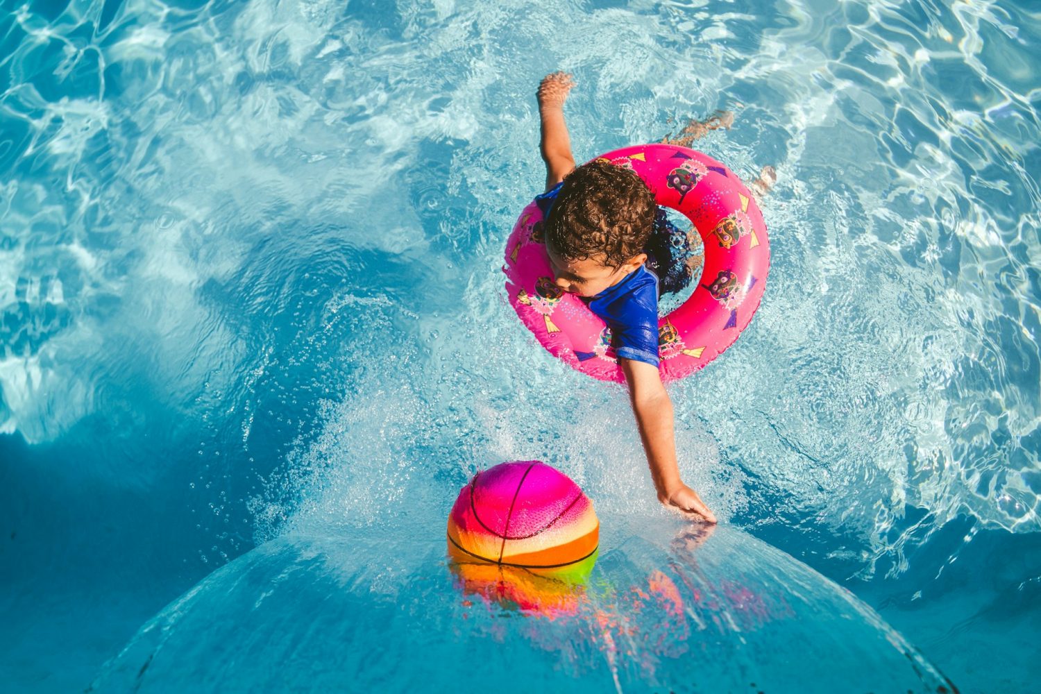 Kid in swim ring in pool. Hotels with indoor waterparks.