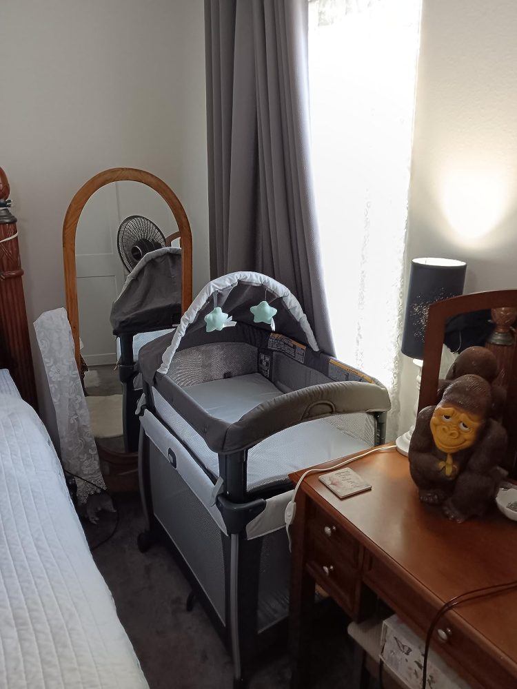 Graco travel crib set up near parents' bed.