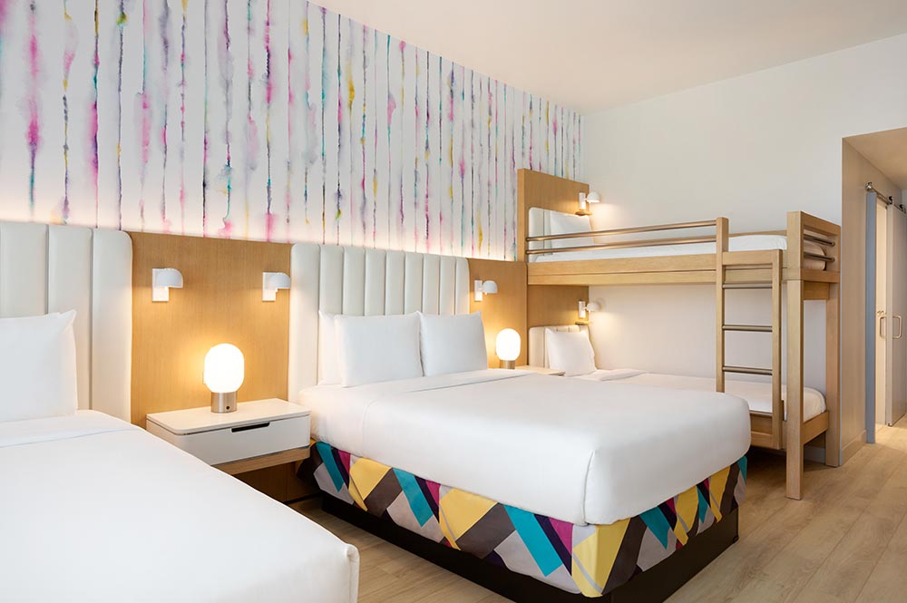 Two queen beds and a bunk bed room at The Viv Hotel