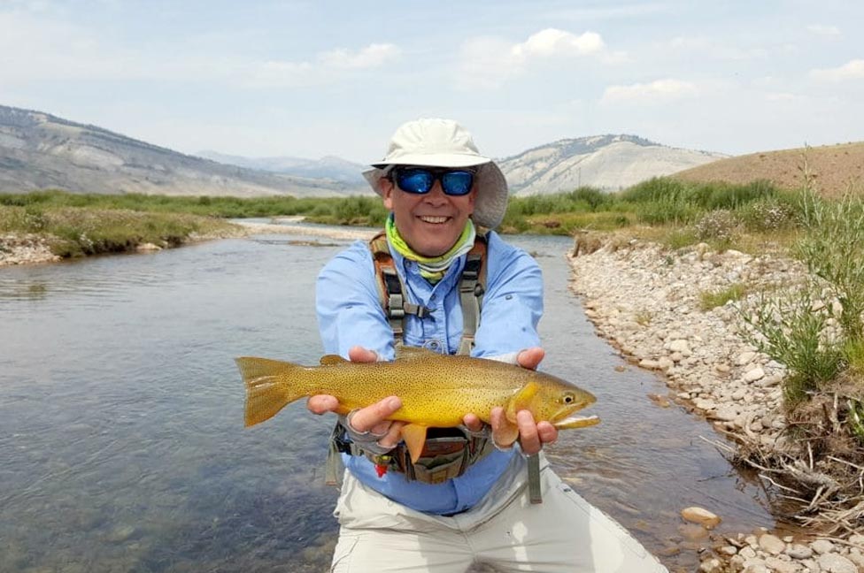 a man with his catch while Fly fishing