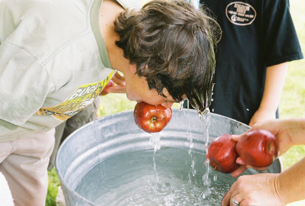 Apple bobber grabs an apple with his mouth