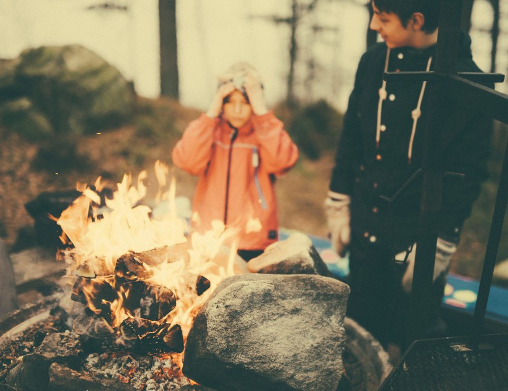 two boys at campfire - best family campsites, family travel