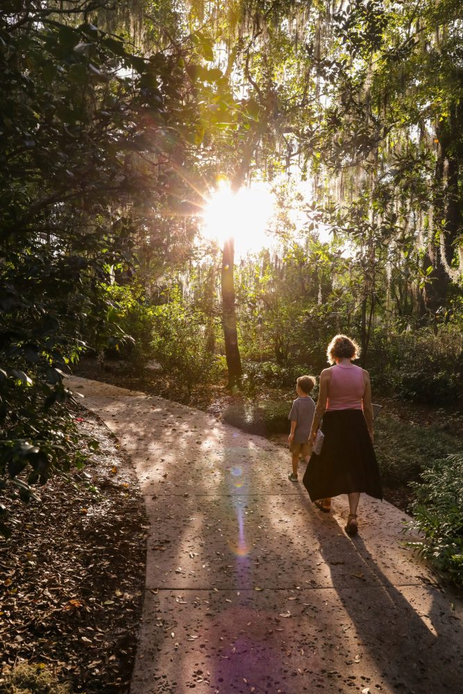 mom and son walking through a sunny garden orlando