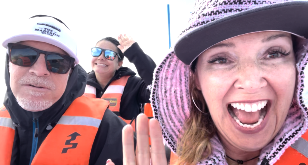 author waving at camera with two other people looking