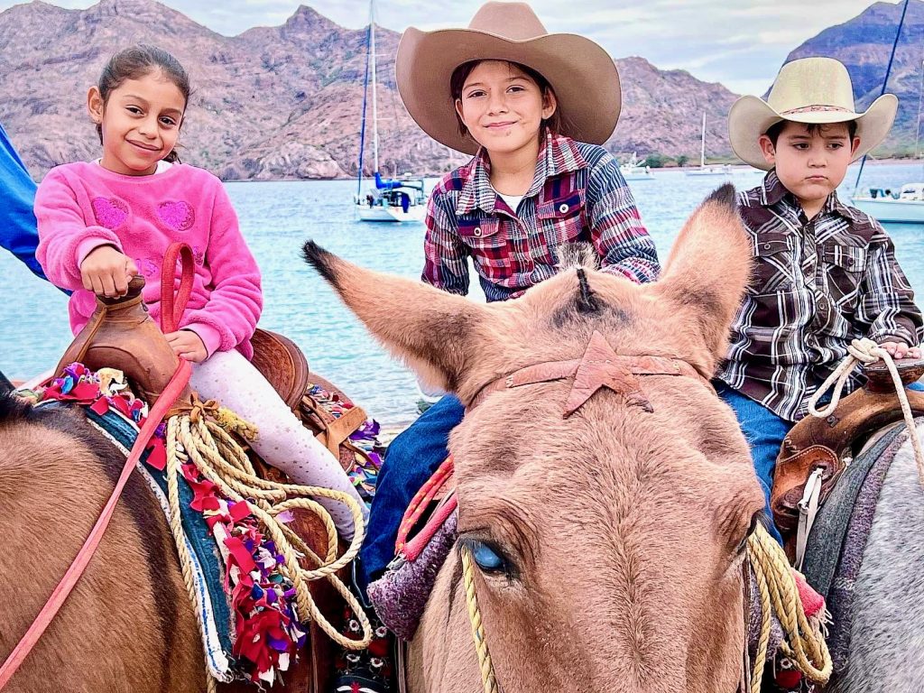 Close-up of three kids on horseback
