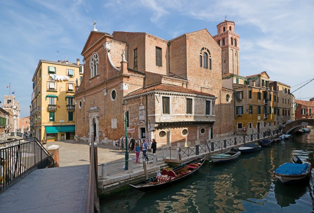 gondolas along a canal by houses