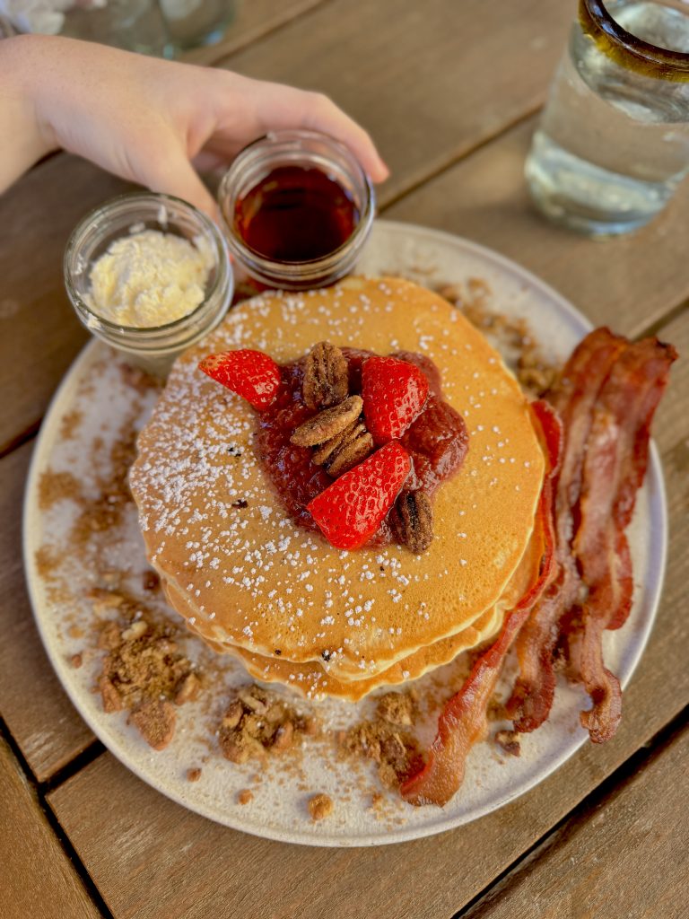 A Texas size order of pancakes, bacon and berries. Don't forget the maple syrup.