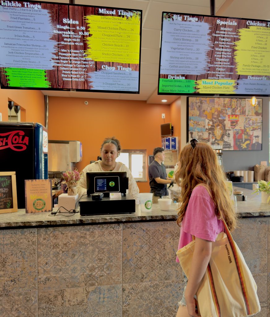 Girl at counter of Jerk Shack ready to order some of the best Caribbean-inspired food in San Antonio Texas. 