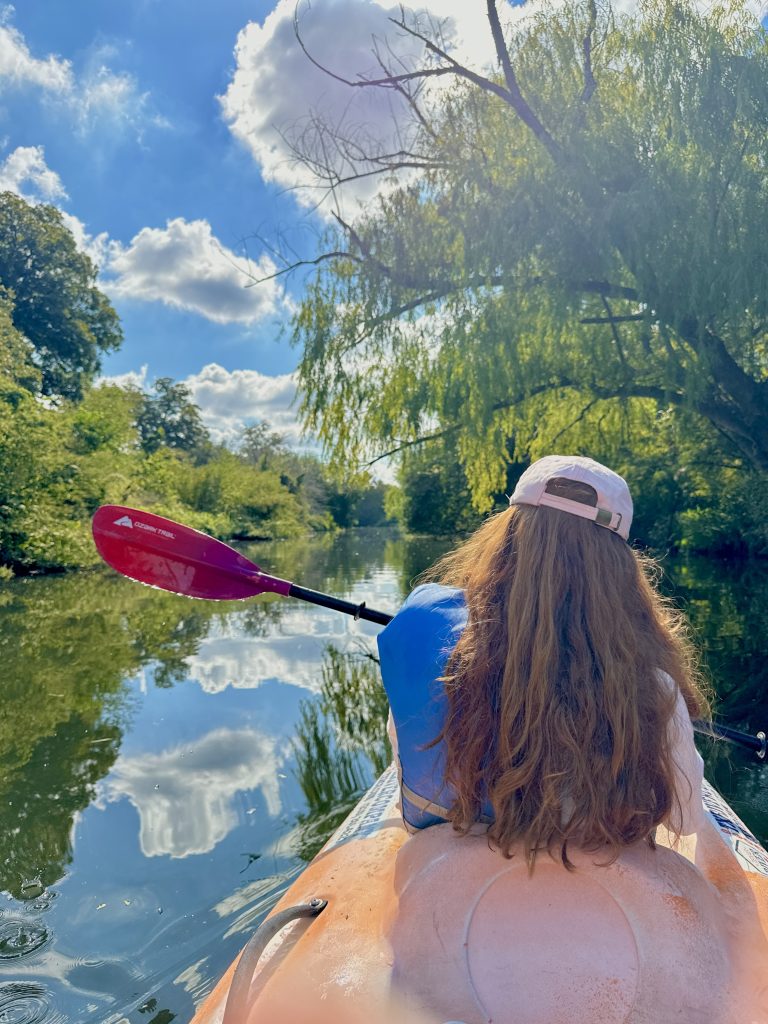 Girl kayaking the San Antonio River with gorgeous trees everywhere. 