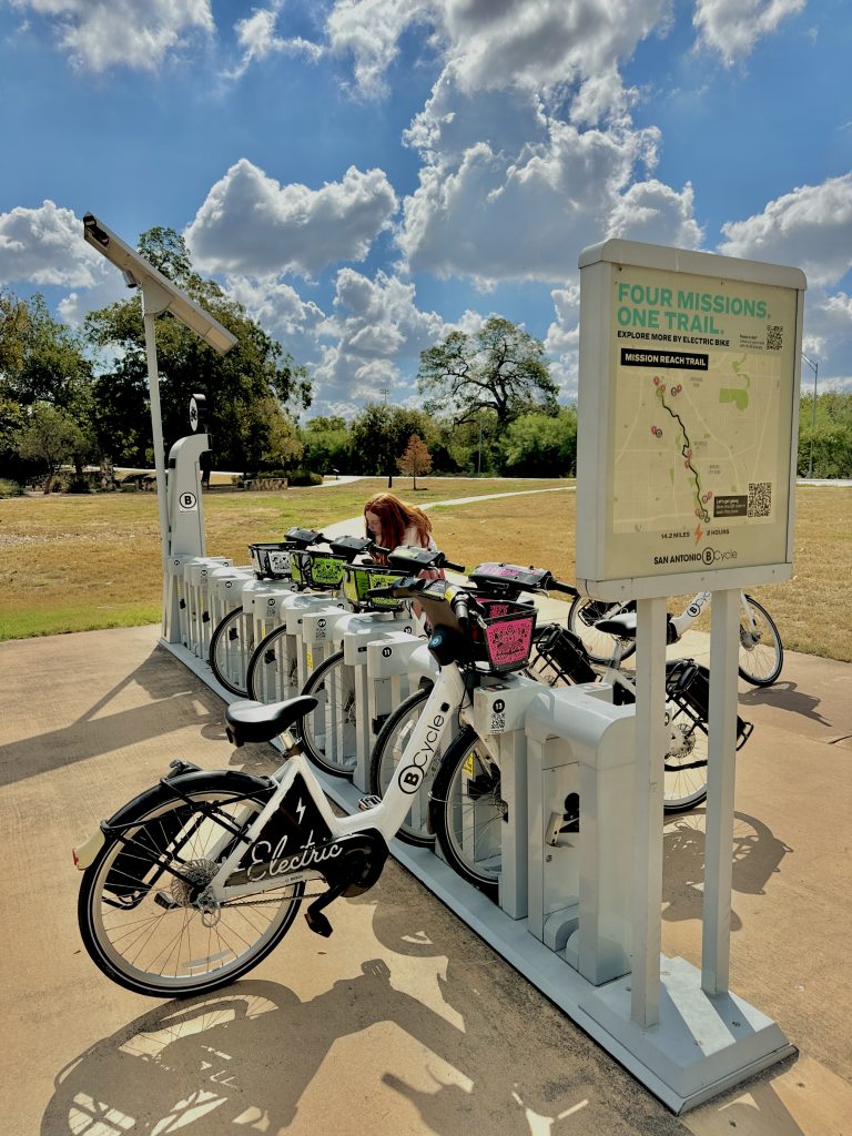 Girl unlocking bike in San Antonio to go on bike ride around the river. 