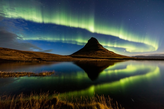 Northern Lights over mountain and water.