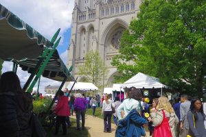 Flower vendor displays and vistors walking by the cathedral.