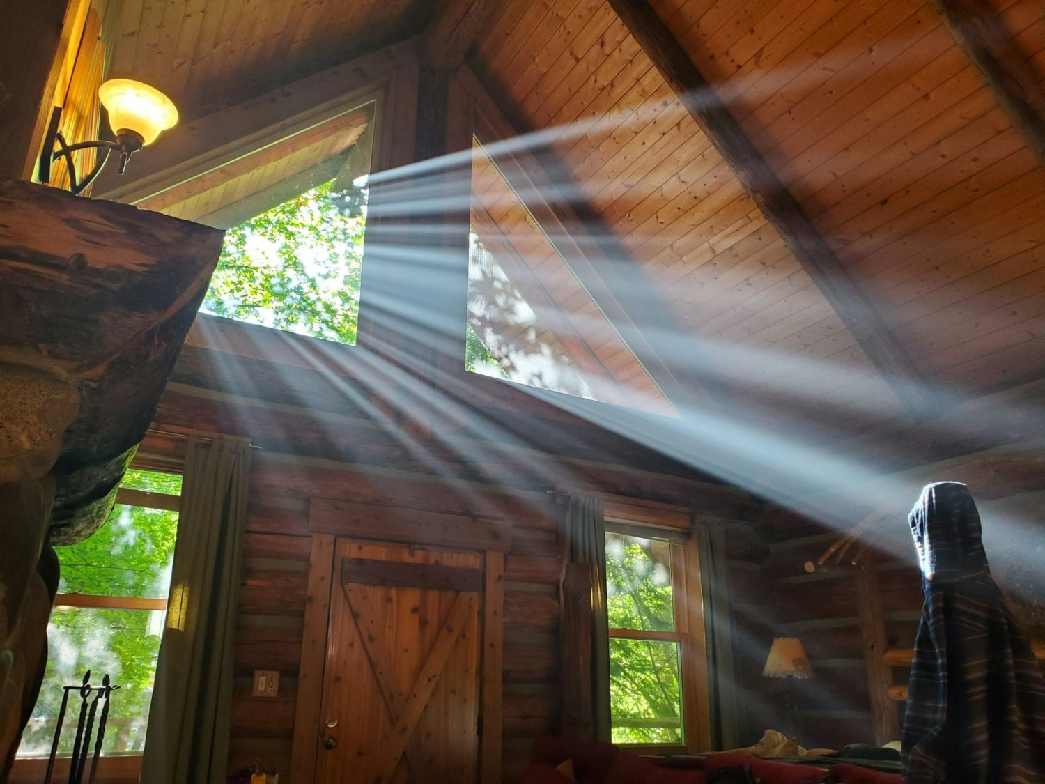 Sun filtering through a cabin's windows in the woods. Hocking Hills romantic getaways.