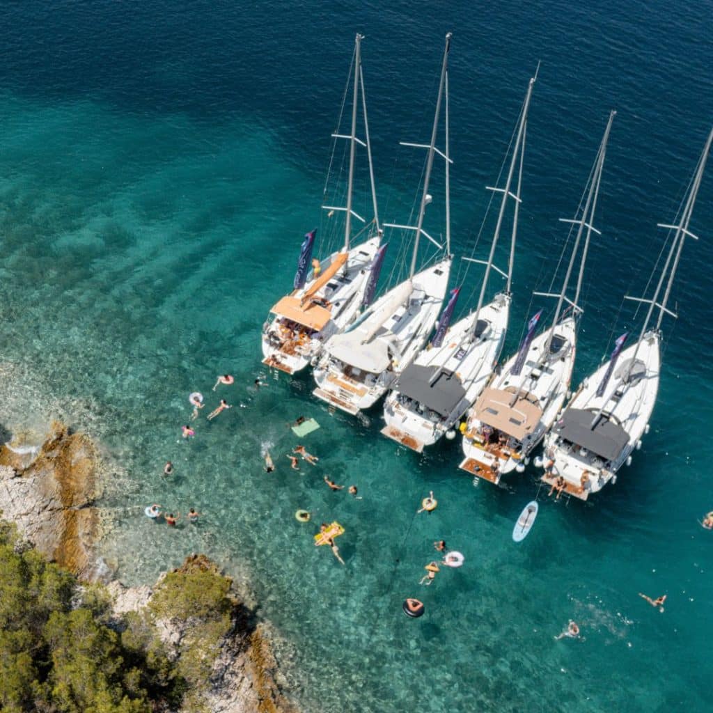 sailboats from above floating on an aquamarine ocean