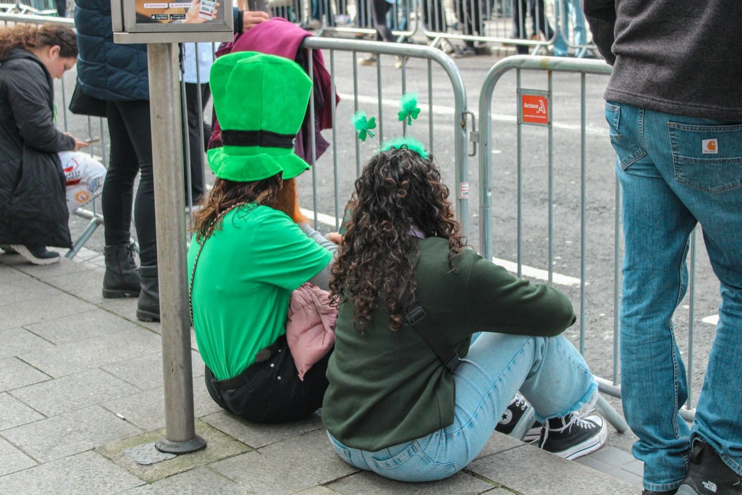 Two people sitting at the St. Patrick's Day Parade. St. Patrick's Day in New York City.