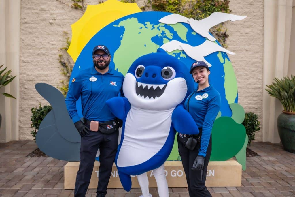 two people between a person in shark costume
