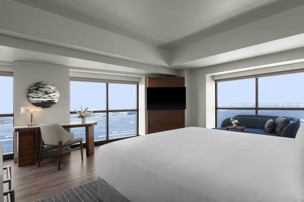 king sized bed corner room with ocean view