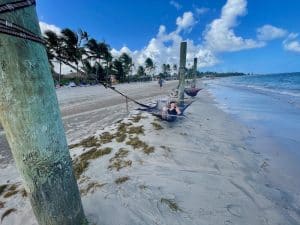 woman laying in hammock by caribbean ocean