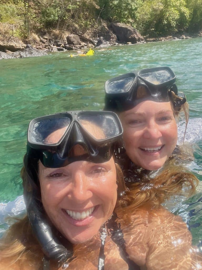 two women in water with snorkel masks