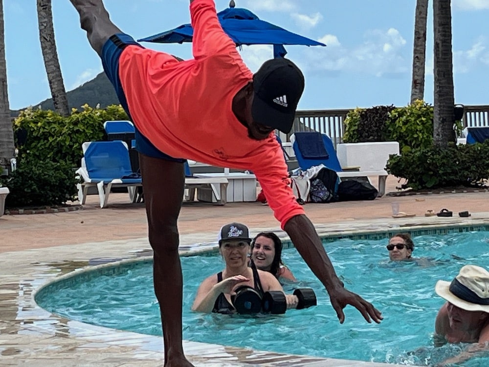 man balancing on one leg by pool