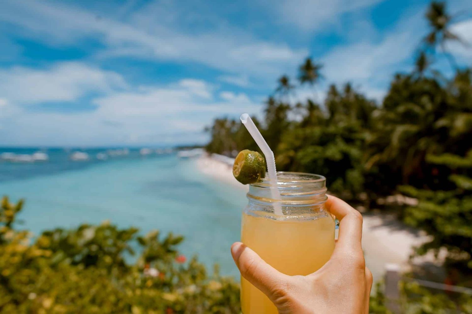 Cocktail with views of the coastline in the background. Best beaches in Antigua.