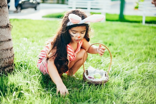 girl with bunny ears collecting easter eggs