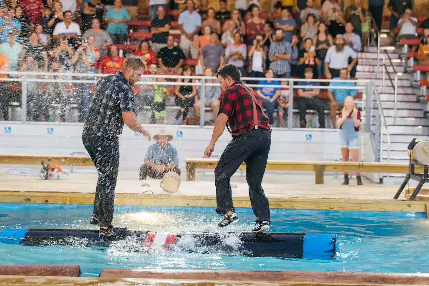 Two men on logs in water competing at Paula Deen's Lumberjack Show. Things to do in Pigeon Forge with kids. 