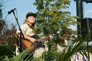 woman playing acoustic guitar among tropical plants