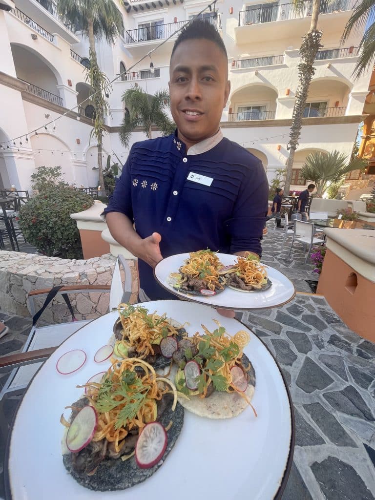 tacos on a plate with man serving