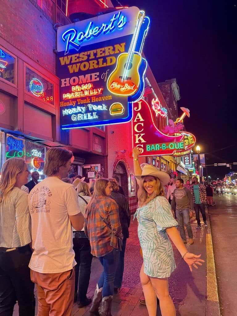 woman in cowboy hat standing in front of Robert's sign