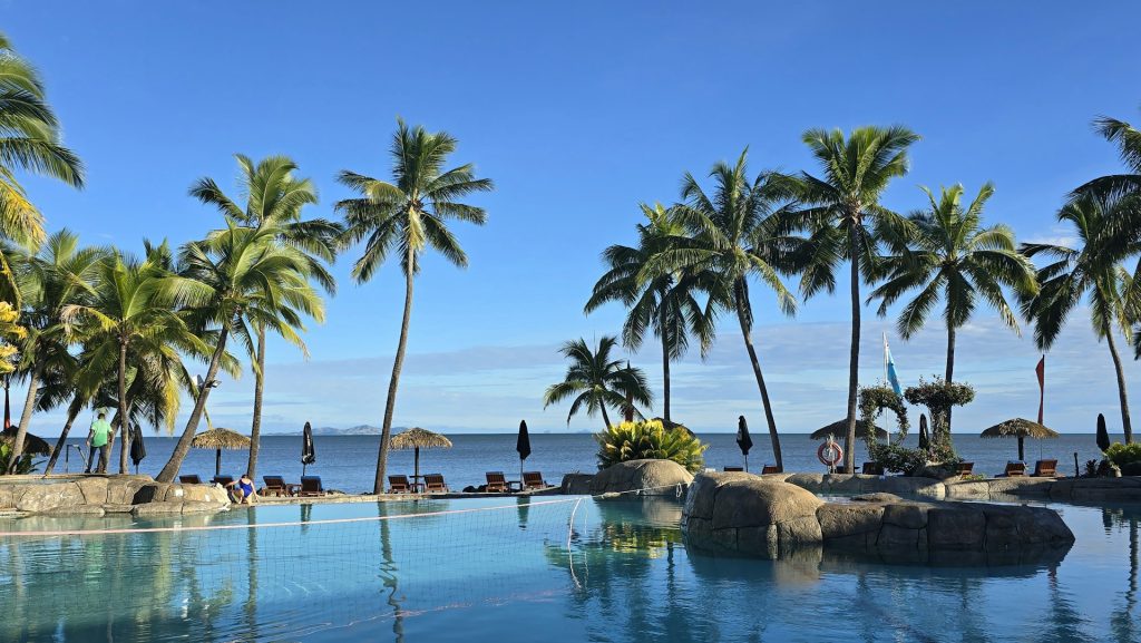 pool by palm trees and ocean