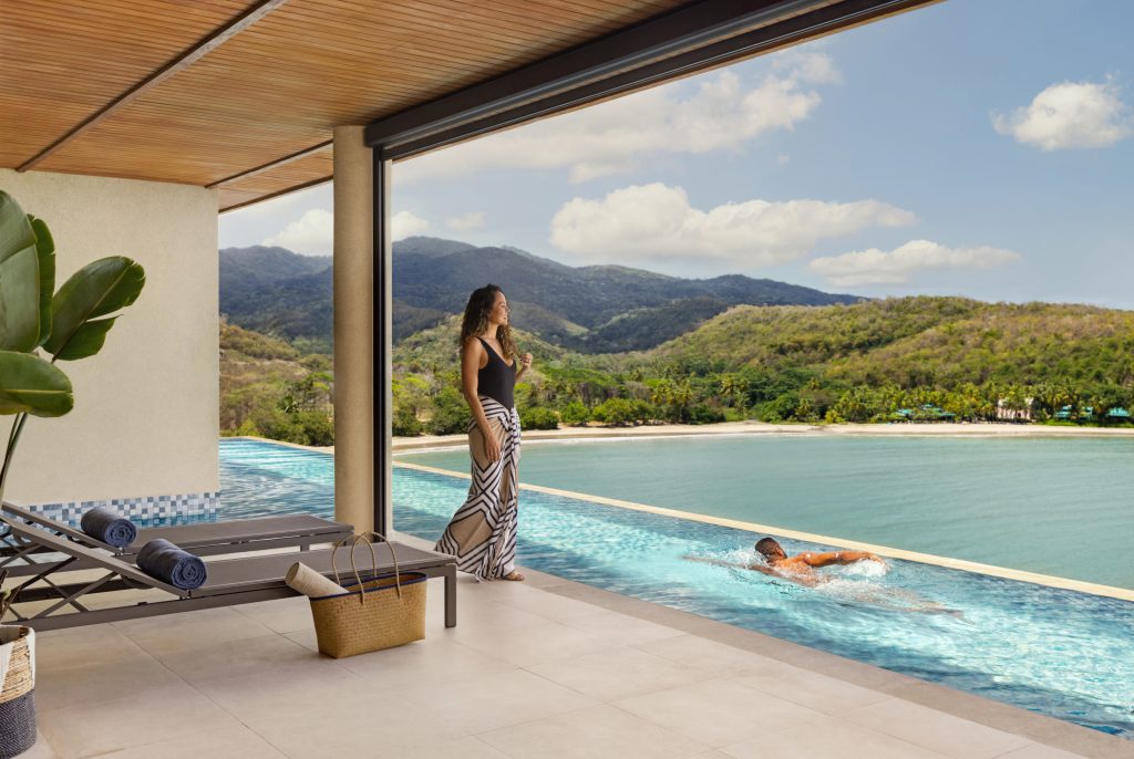 dad swimming in lap pool with green mountains in background