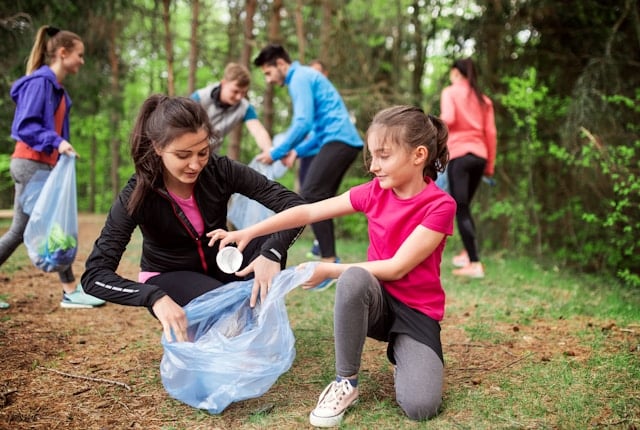 kids picking up trash in woods