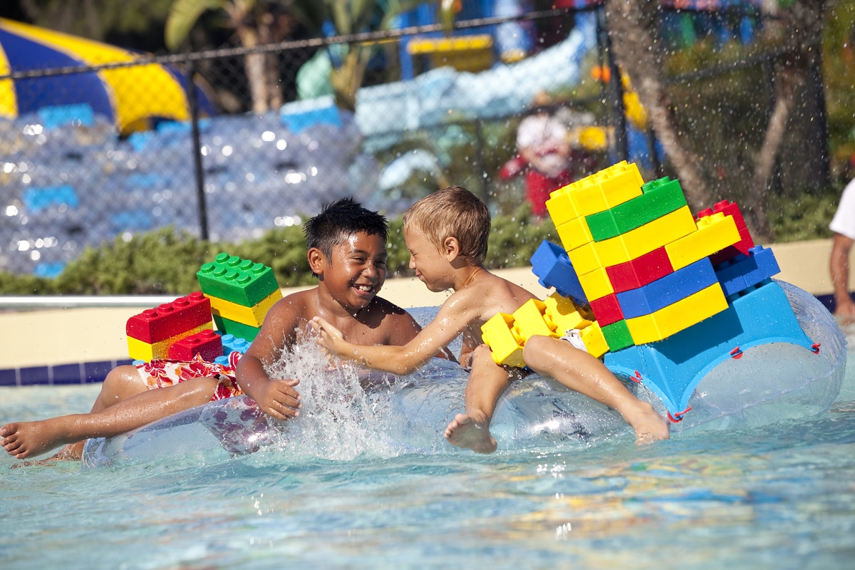 Two kids splashing in the pool at LEGOland resort. All-inclusive kid-friendly resorts in Florida. 