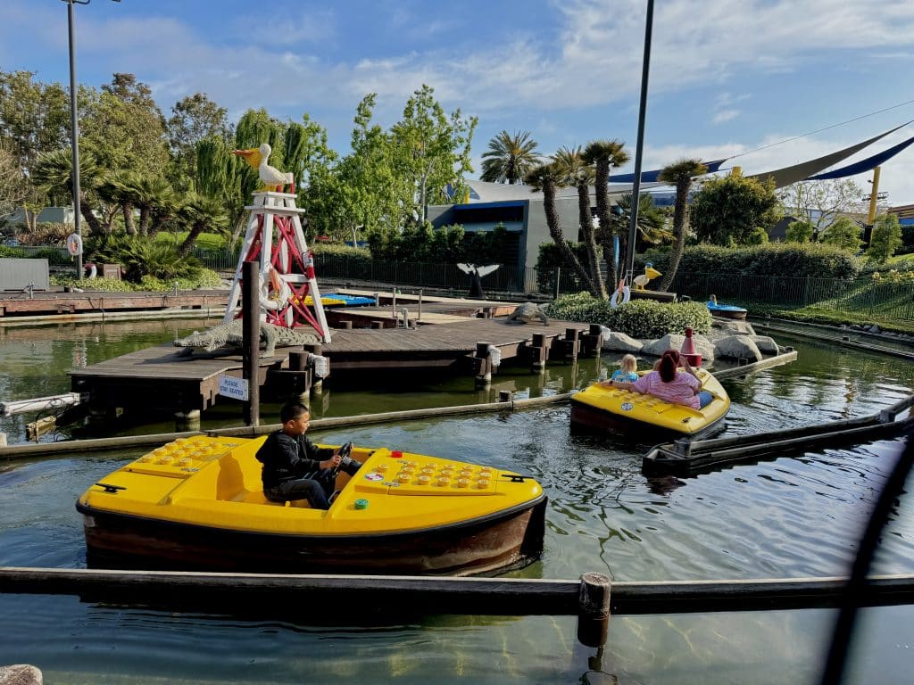 Small Lego boats take families around a lagoon. 