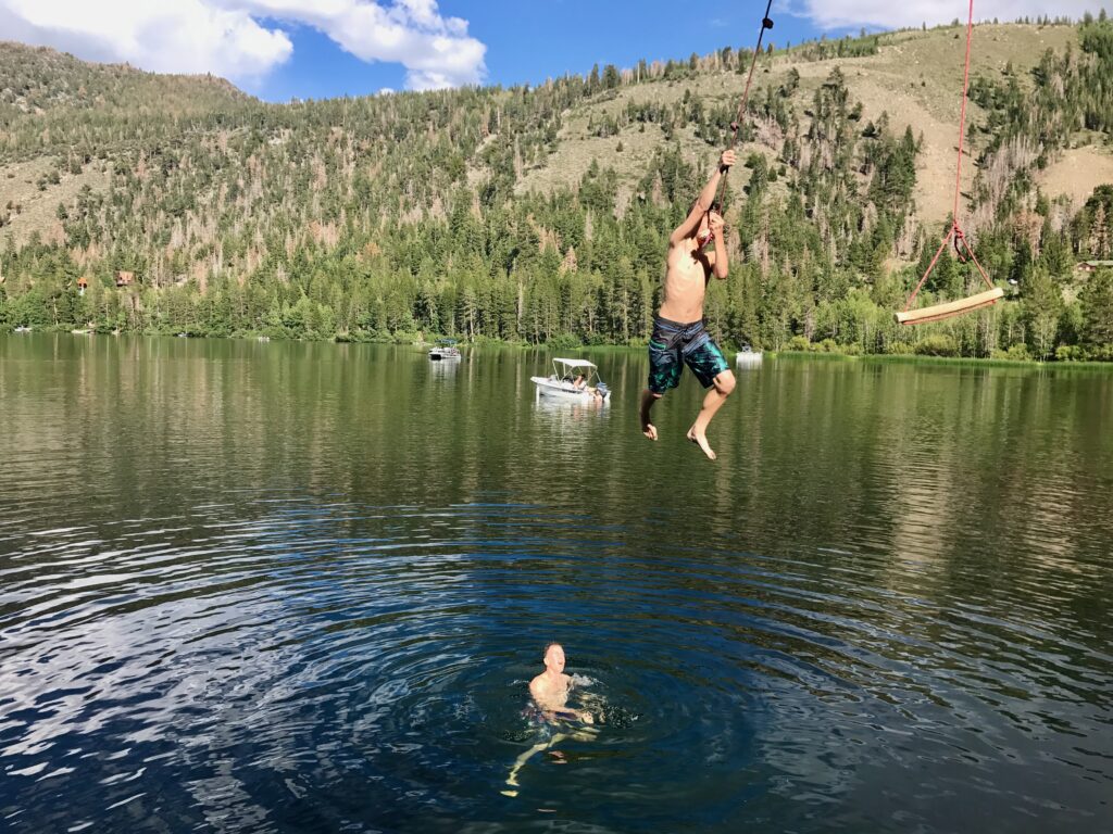 boy jumping into lake
