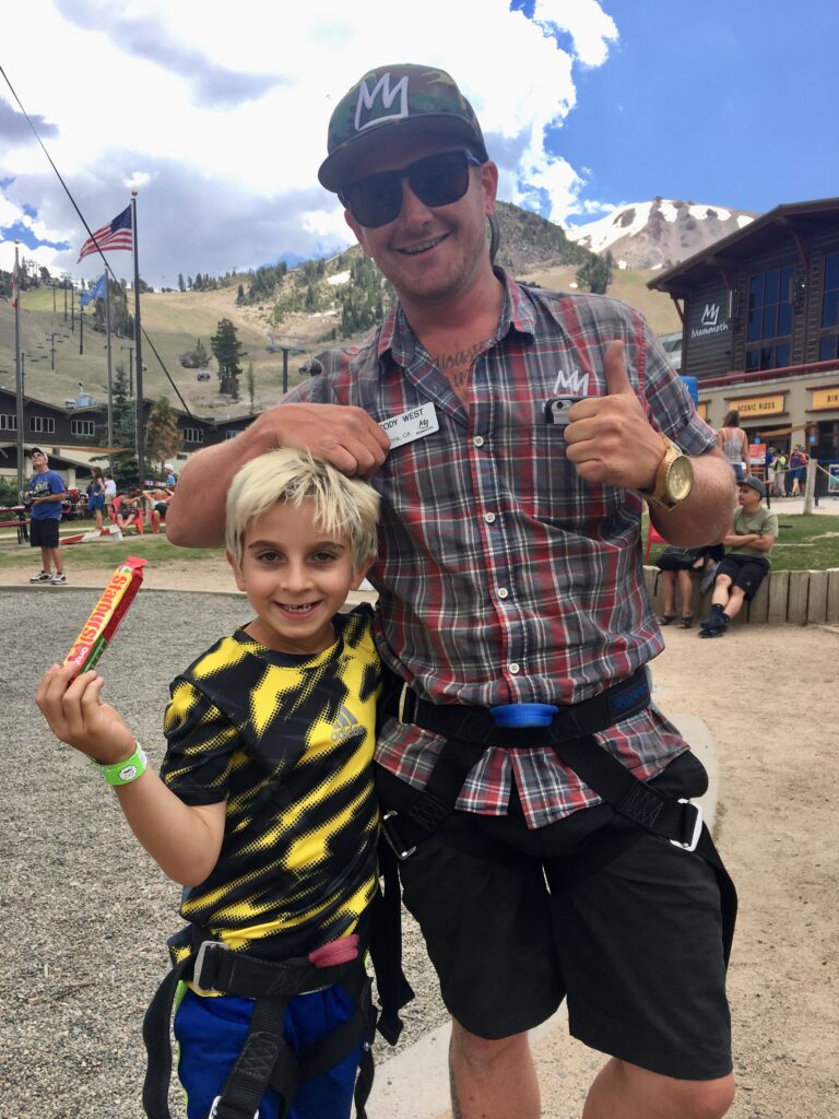 boy standing next to man and holding starburst candy